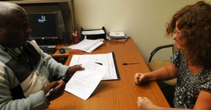 Picture of a man and a woman seated at a table discussing documentstogether